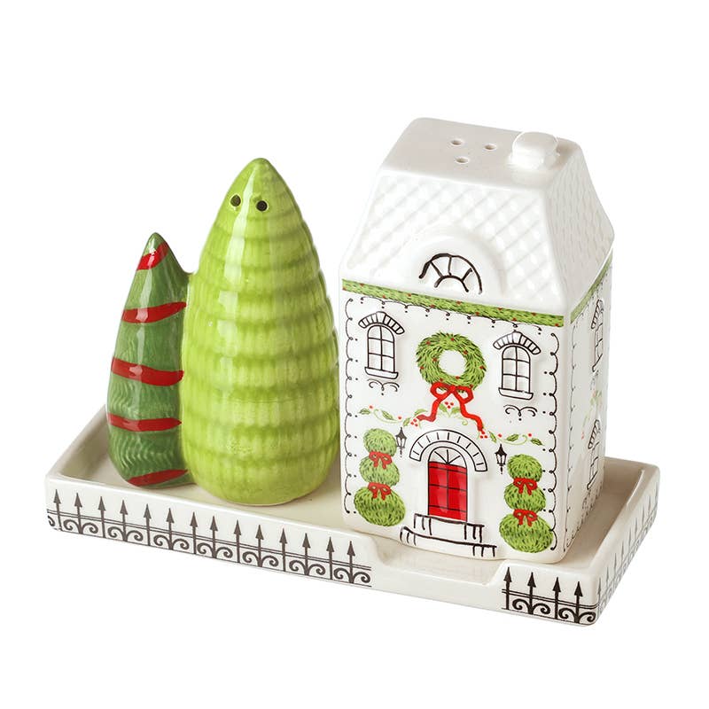 Decorative salt and pepper shakers with a house-shaped pepper grinder on a white tray.